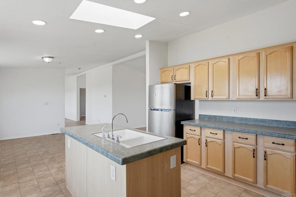 909 Tierra De Luna Road Boulevard, CA 91905 - Photo 9 of 74 a kitchen with a sink a refrigerator and cabinets
