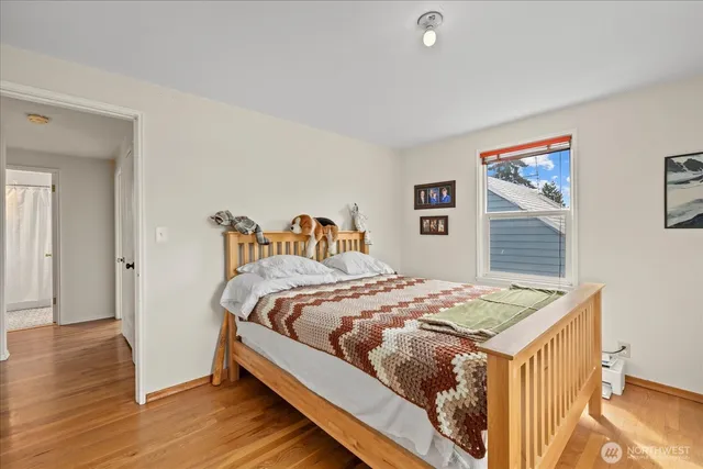 a bedroom with a bed and wooden floor