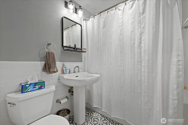 a bathroom with a sink a toilet and shower curtain