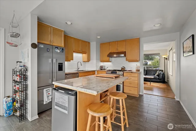 a kitchen with stainless steel appliances granite countertop a refrigerator and a stove top oven