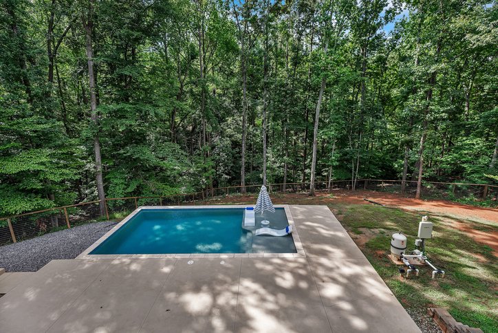 1422 Hunters Trail Anderson, SC 29625 - Photo 30 of 41 An inviting backyard oasis offers a serene pool, complemented by a private, tree-lined setting.