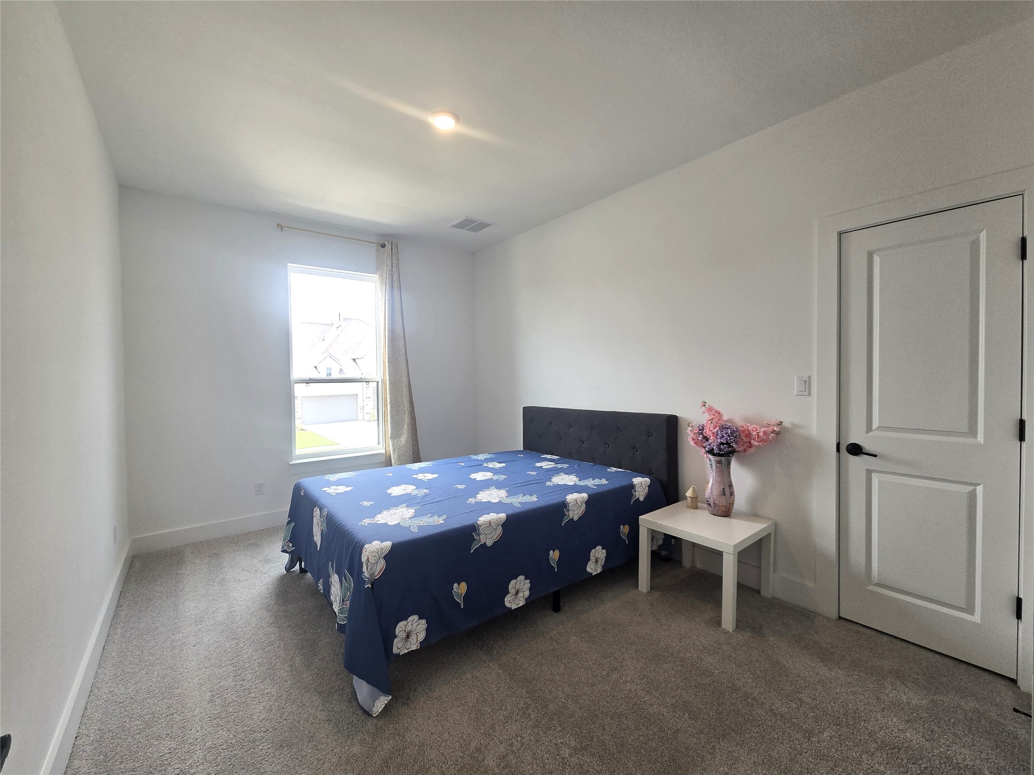 124 Ribera Drive Liberty Hill, TX 78642 - Photo 19 of 40 A comfortable bedroom, featuring a bright window and soft carpeting for peaceful living.
