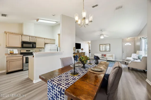 a living room with furniture a dining table and paintings on the wall