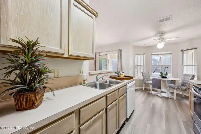 a kitchen with granite countertop a sink a counter top space appliances and cabinets