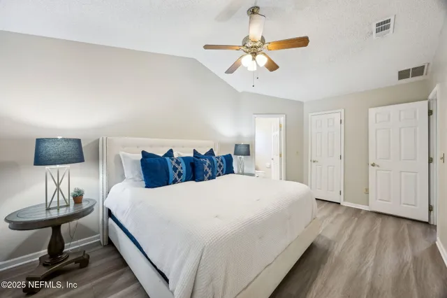 a living room with a bed and a ceiling fan