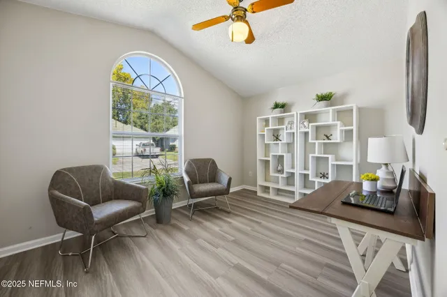 a living room with furniture a chandelier and a window