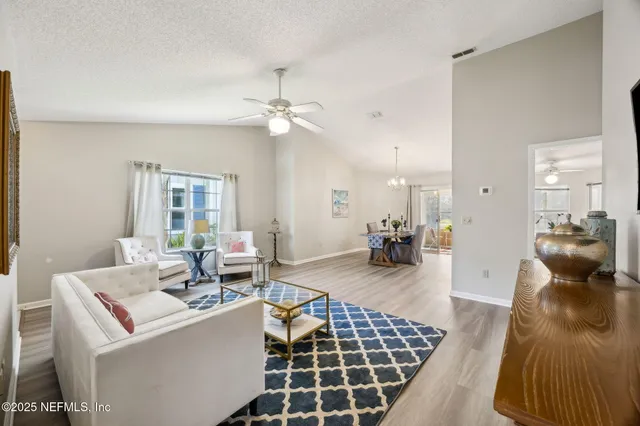 a living room with furniture a flat screen tv and kitchen view