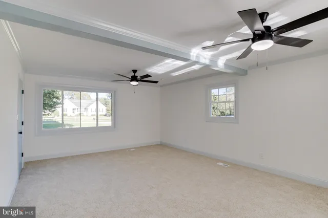 en empty room with windows and ceiling fan