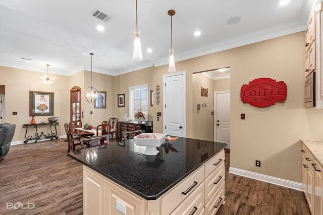 a kitchen with granite countertop a sink a counter top space and living room view