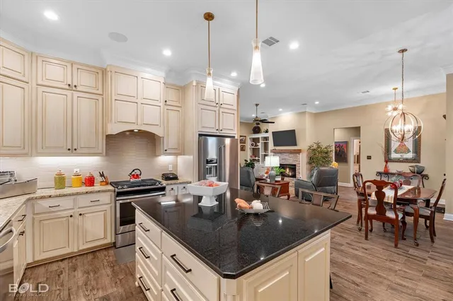 a kitchen with stainless steel appliances granite countertop a sink a stove and a refrigerator