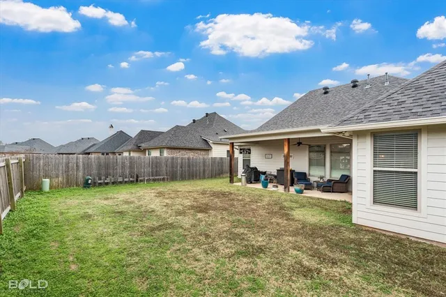 a view of a house with a yard and wooden fence