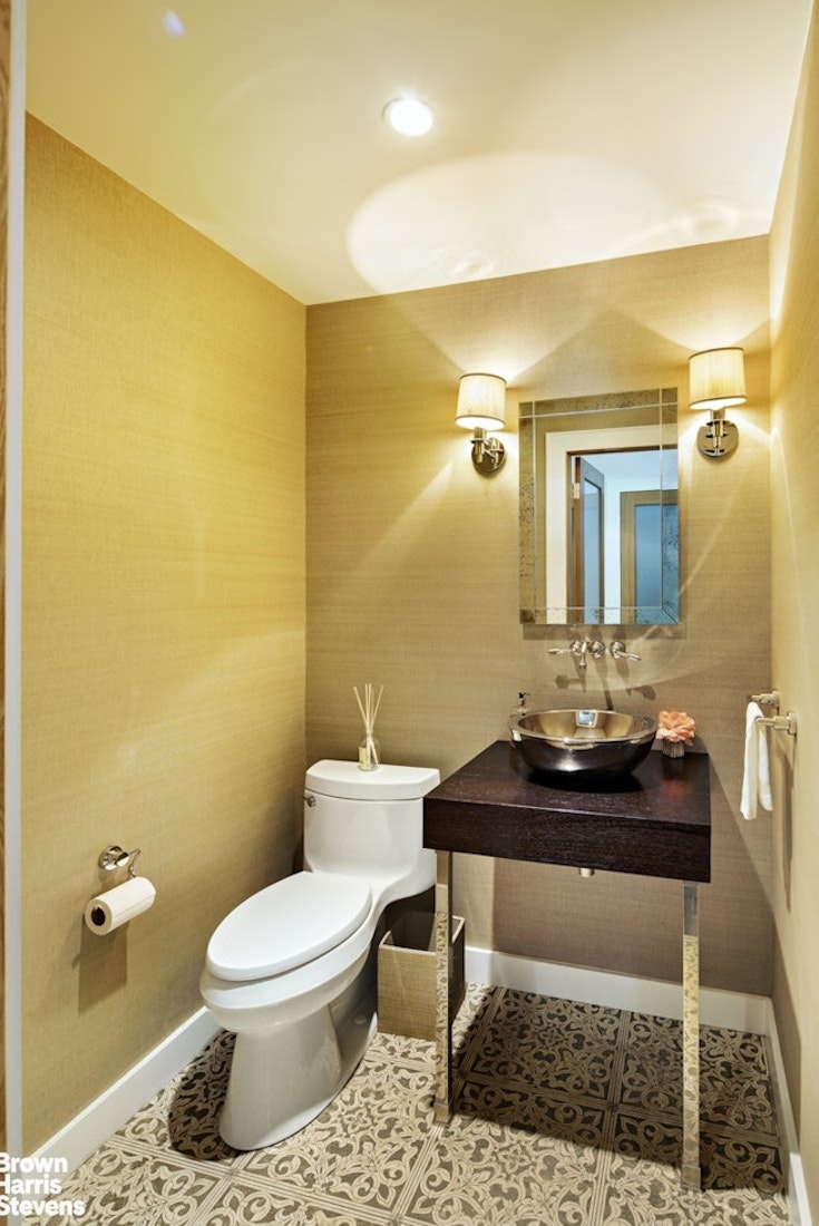 425 East 58th Street, Unit 7D Manhattan, NY 10022 - Photo 11 of 13 a bathroom with a toilet a sink and mirror