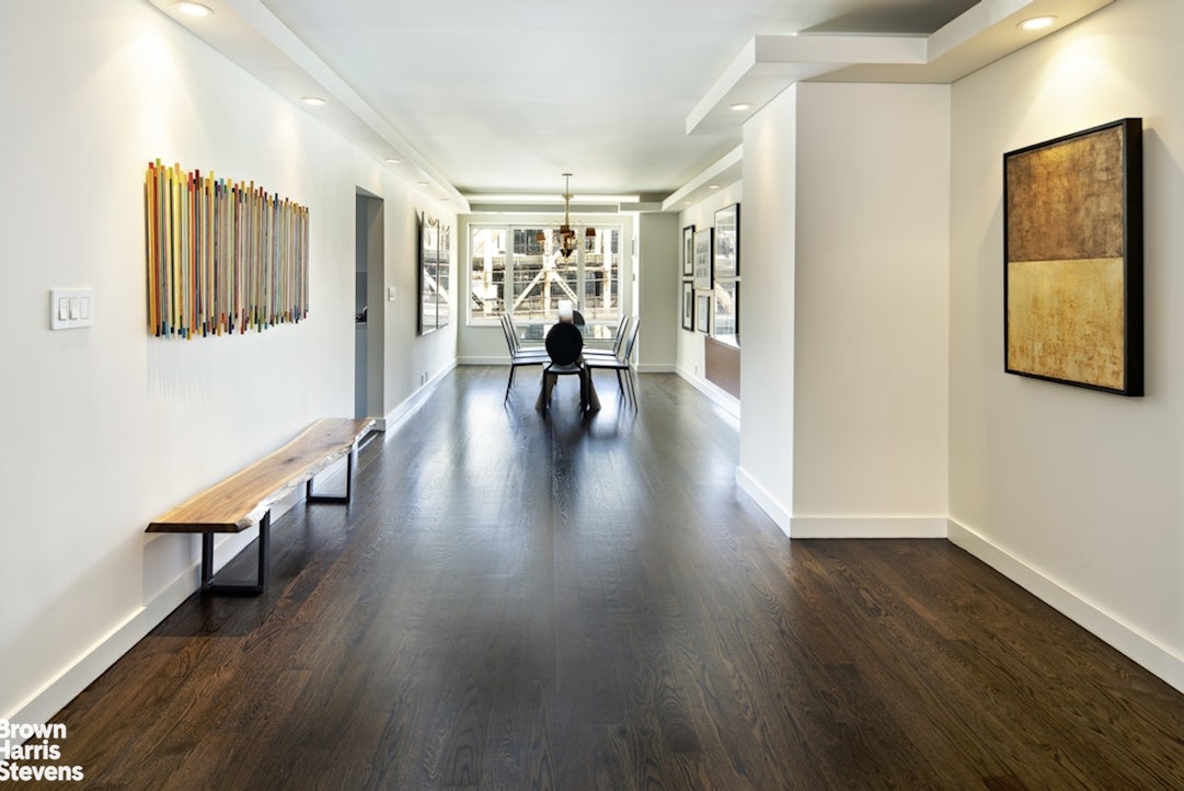 425 East 58th Street, Unit 7D Manhattan, NY 10022 - Photo 3 of 13 a hallway with wooden floor lounge chair and windows