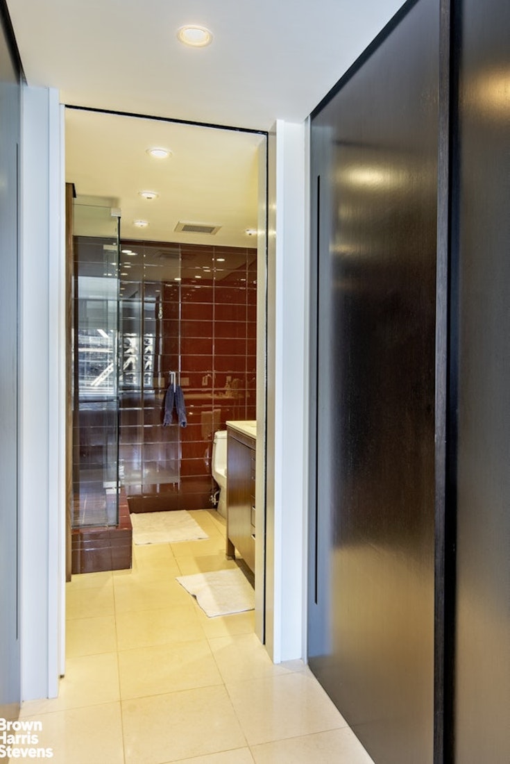 425 East 58th Street, Unit 7D Manhattan, NY 10022 - Photo 8 of 13 a bathroom with a glass shower door