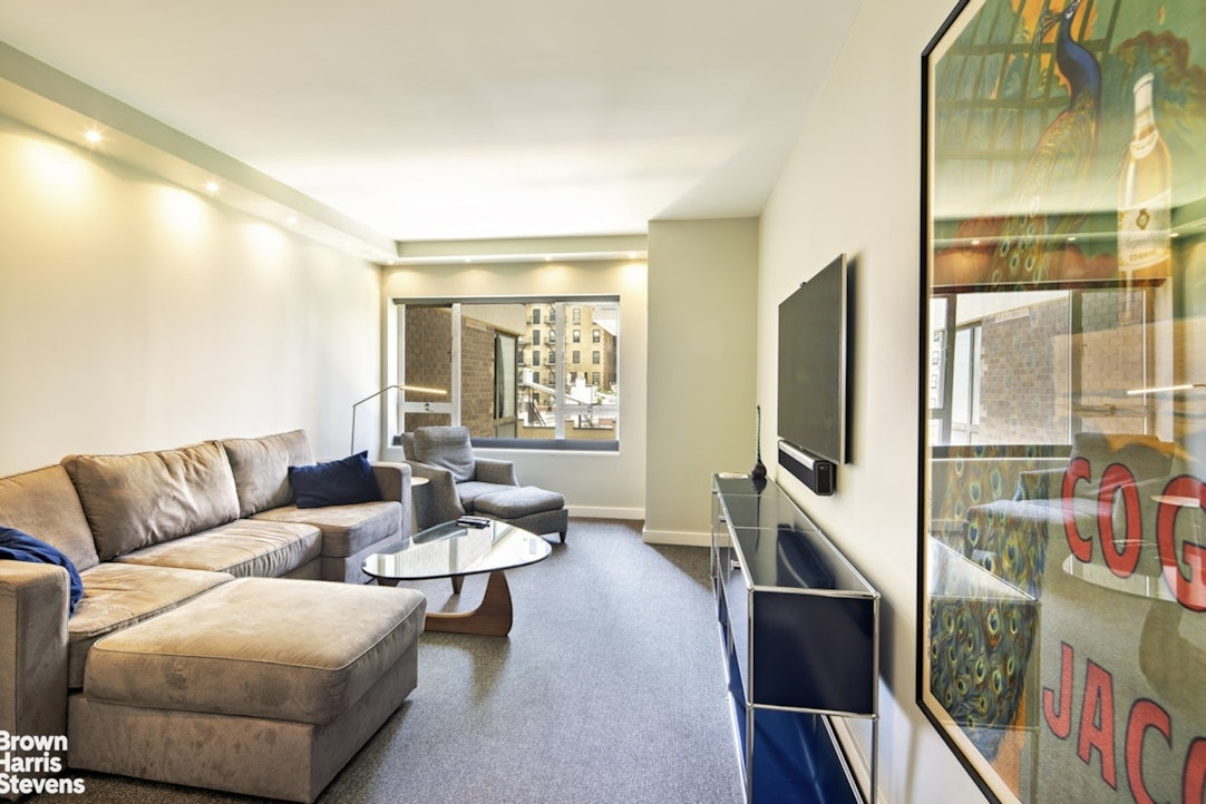 425 East 58th Street, Unit 7D Manhattan, NY 10022 - Photo 9 of 13 a living room with furniture and a flat screen tv