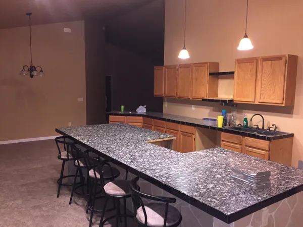 a kitchen with stainless steel appliances granite countertop a sink dishwasher a stove a refrigerator a sink with island and chairs