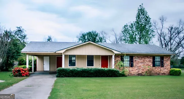 a front view of a house with a garden