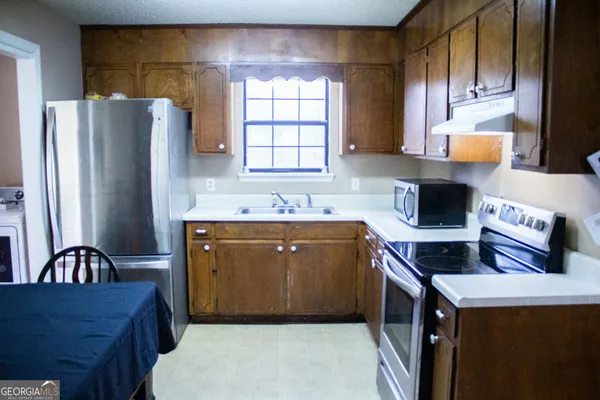 a kitchen with stainless steel appliances granite countertop a refrigerator sink and cabinets