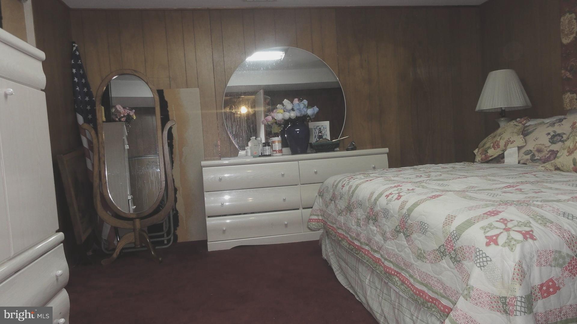 4014 Starbrook Road Randallstown, MD 21133 - Photo 22 of 30 a bedroom with a bed a mirror and dresser
