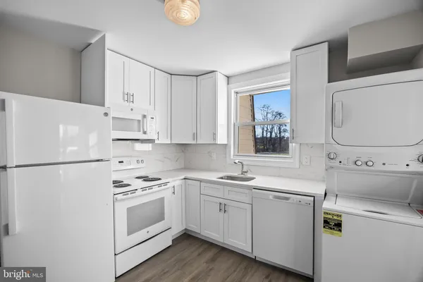 a kitchen with white cabinets and white appliances