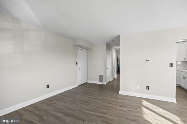 a view of an empty room with wooden floor