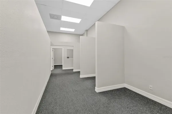 an empty room with a window and swimming pool