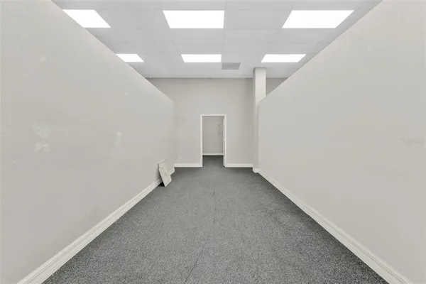 an empty room with a hallway and closet