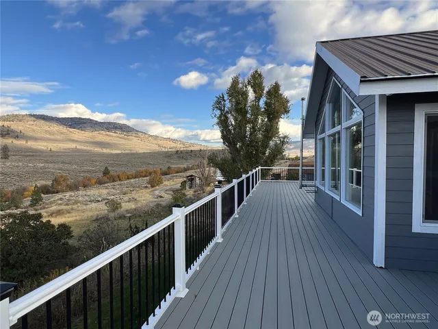 a view of a balcony with wooden floor and fence