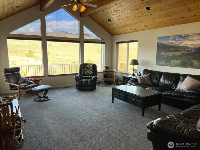 a living room with furniture and a floor to ceiling window