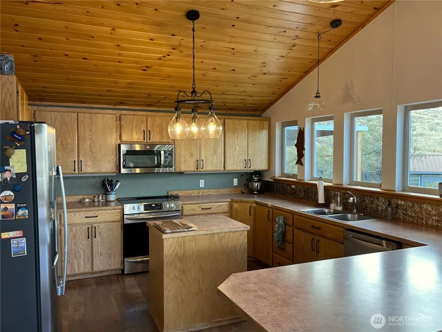 a kitchen with stainless steel appliances granite countertop a sink a stove and a refrigerator