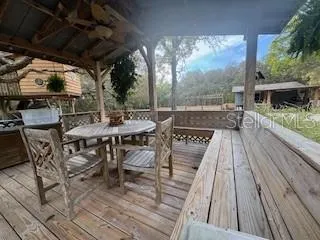 a view of a patio with table and chairs with wooden floor and fence