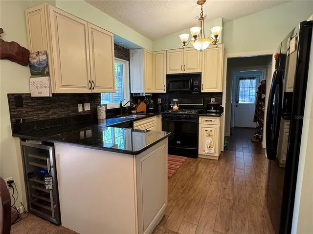 a kitchen with stainless steel appliances granite countertop a stove top oven a sink dishwasher and a refrigerator