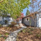 a backyard of a house with large trees and brick walls