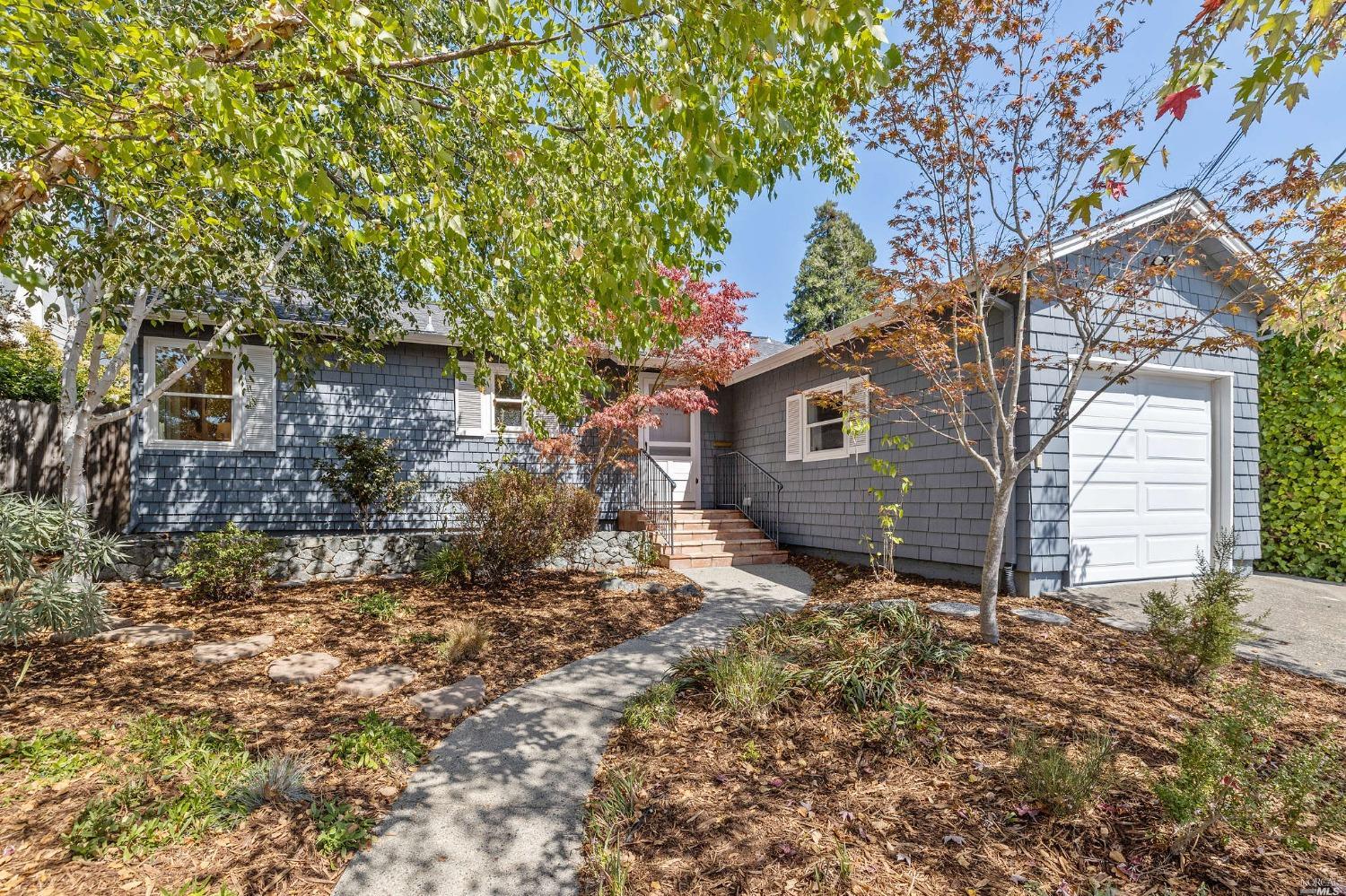 a backyard of a house with large trees and brick walls
