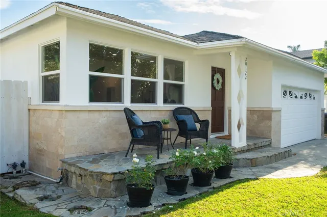 a view of a house with backyard and sitting area