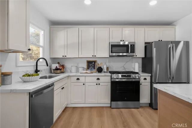 a kitchen with stainless steel appliances granite countertop a stove a sink and a refrigerator