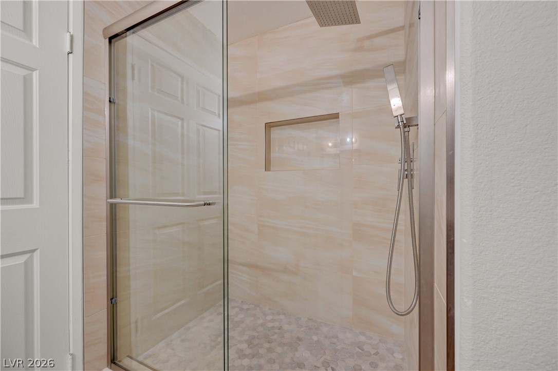 7885 West Flamingo Road, Unit 1050 Las Vegas, NV 89147 - Photo 25 of 62 A sleek, contemporary walk-in shower features a glass enclosure and recessed shelf.