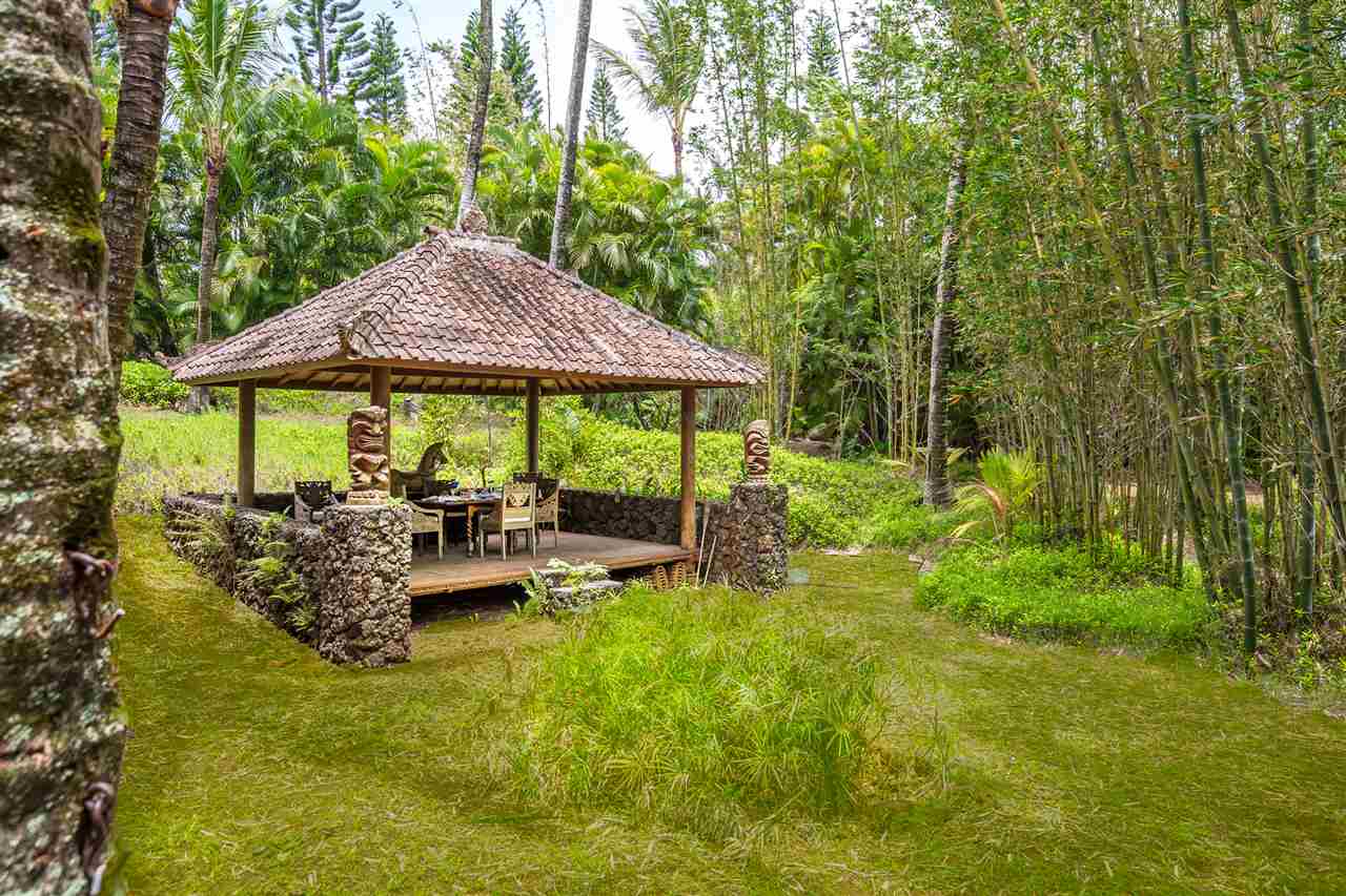 73 Door Of Faith Road Haiku, HI 96708 - Photo 25 of 30 a backyard of a house with table and chairs under an umbrella