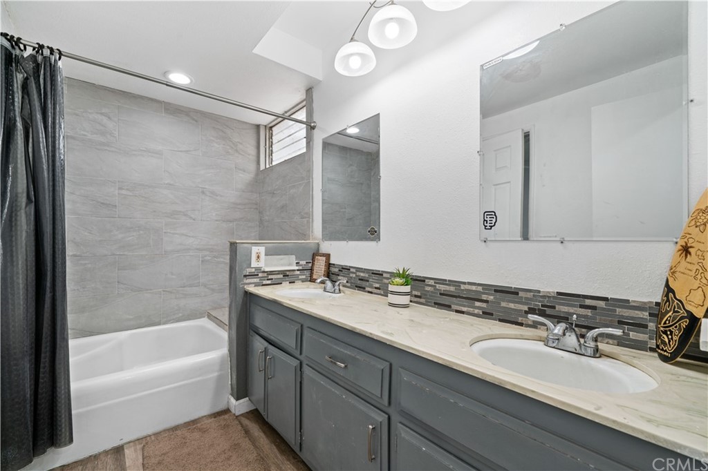 4909 El Molino Avenue Riverside, CA 92504 - Photo 23 of 33 a bathroom with a sink double vanity granite tub shower and a mirror