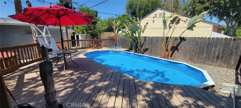 4909 El Molino Avenue Riverside, CA 92504 - Photo 27 of 33 a view of a patio with table and chairs under an umbrella with wooden fence