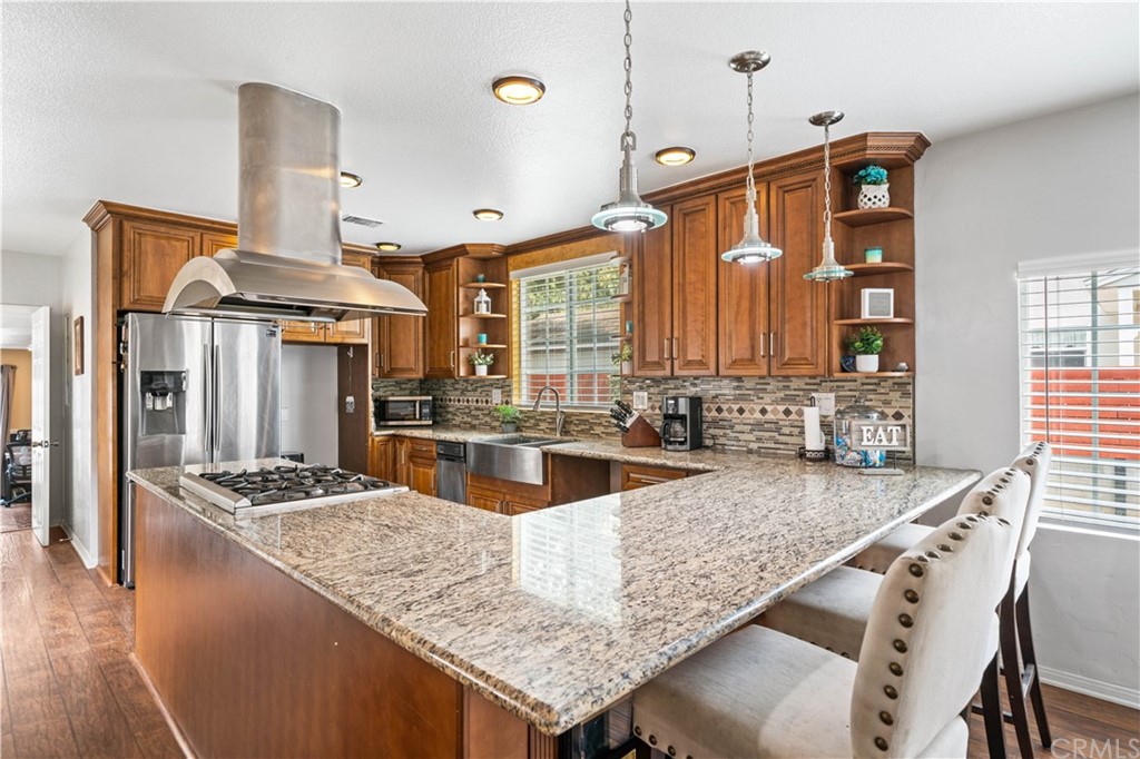 4909 El Molino Avenue Riverside, CA 92504 - Photo 7 of 33 a kitchen with stainless steel appliances granite countertop a sink a stove and a wooden floors