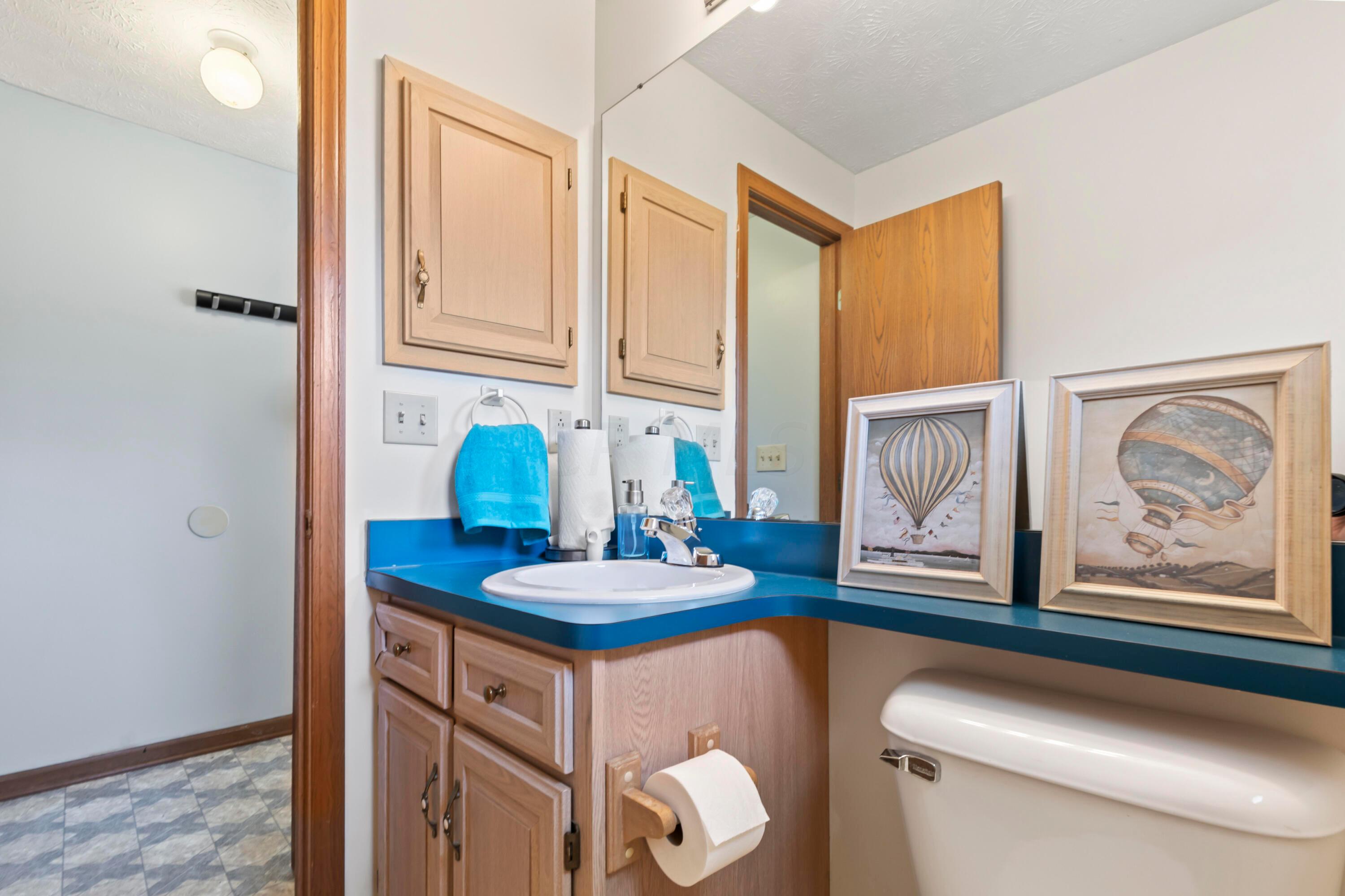 14040 Downing Road Croton, OH 43013 - Photo 30 of 66 • Neutral vinyl flooring
• Ivory painted walls
• Enclosed vanity with
single bowl sinktop
• Medicine cabinet
• Ceiling exhaust
• Studio light strip
• Octagonal window