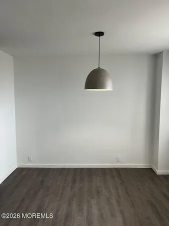 a view of a big room with a chandelier fan and wooden floor