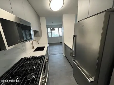 a kitchen with granite countertop a refrigerator and a sink
