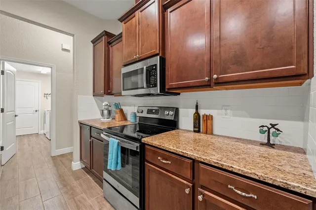a kitchen with stainless steel appliances granite countertop a sink a stove and cabinets