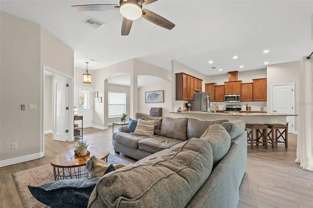 a living room with furniture kitchen and a wooden floor