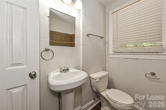 a bathroom with a toilet a sink and a mirror