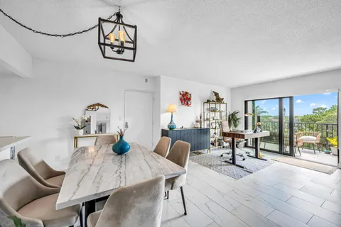 a view of a dining room with furniture a chandelier and wooden floor