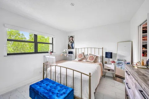 a bedroom with a bed a window and a chandelier