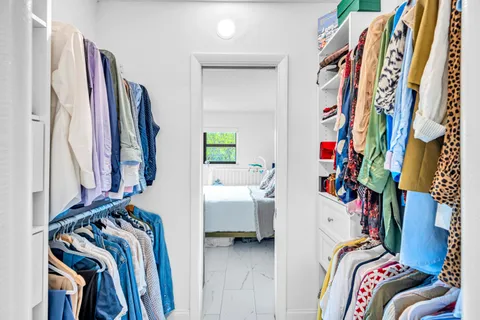 a view of walk in closet with clothes and shoes